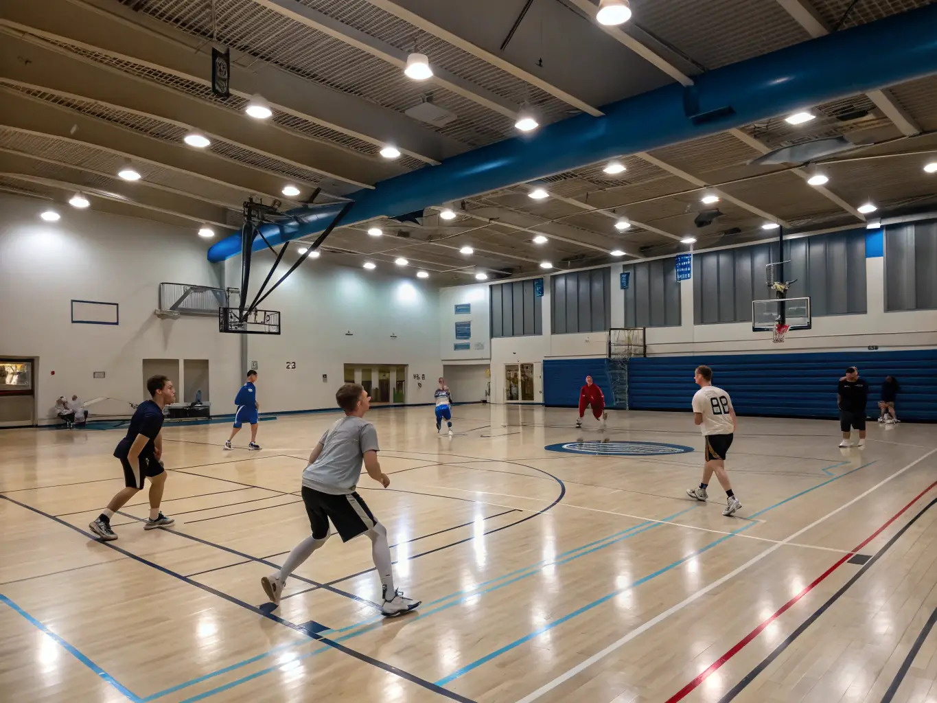 A group of students participating in a basketball training session indoors, focusing on skill development and teamwork.